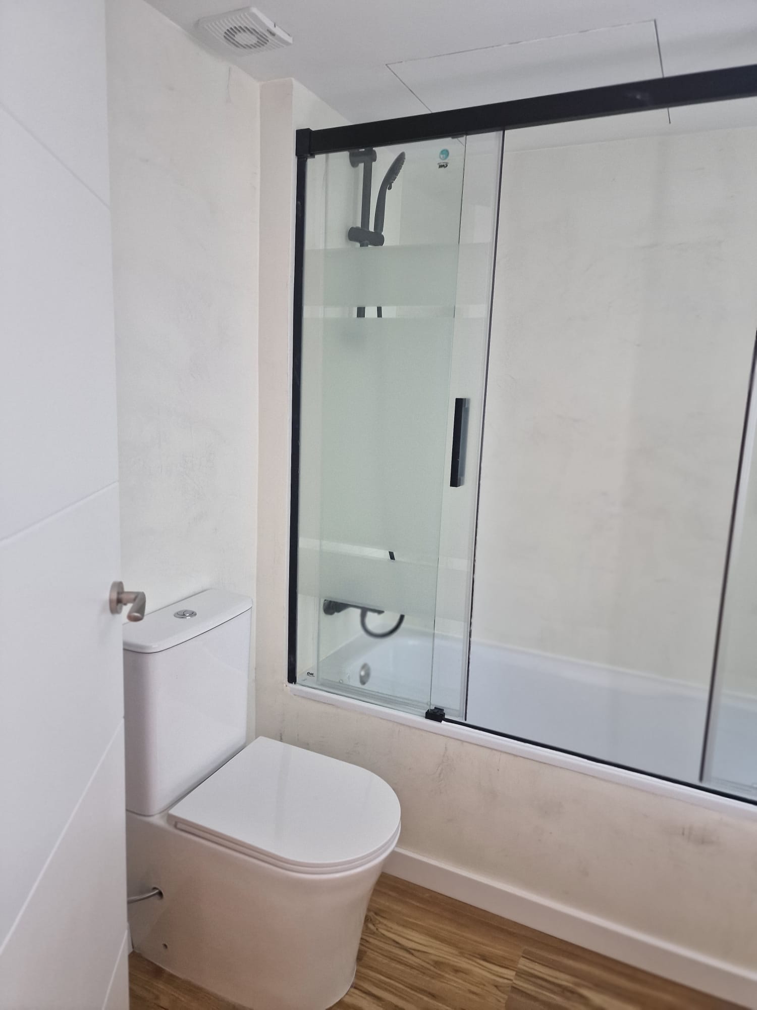 Baño con bañera de gran formato y mampara de vidrio templado Reforma de baño en Sitges | Baño principal en chalet Baño con bañera de gran formato y mampara de vidrio templado
